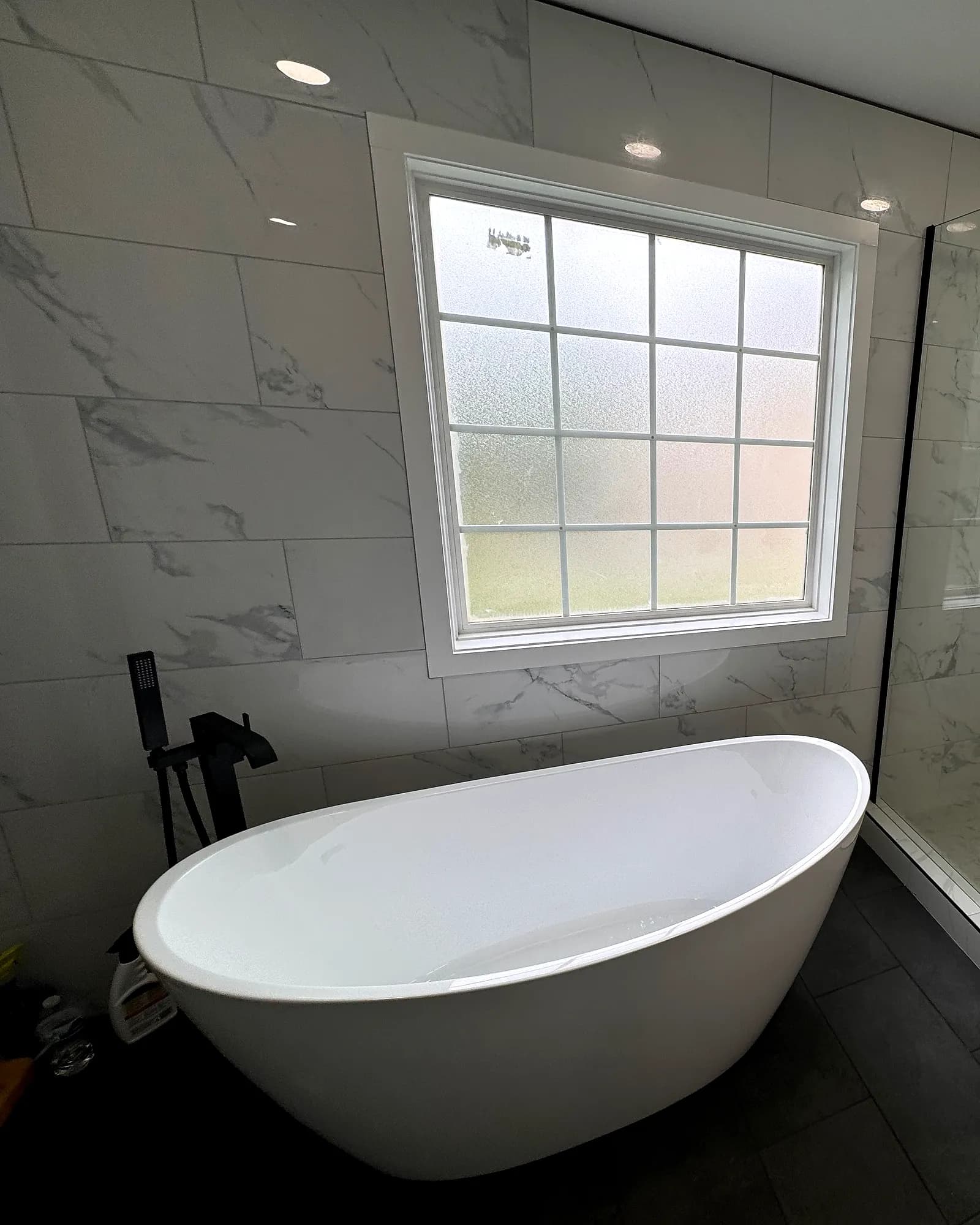 Finished bathroom remodel with a freestanding soaker tub and frameless glass shower by JM Home and Property Services in Clarksville, TN